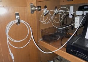 A once-messy cabinet is clean with organized charging cables
