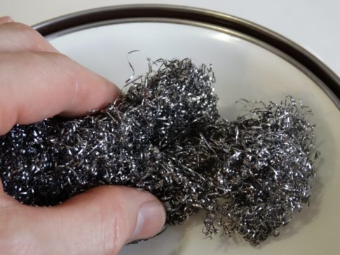 A handing holding a piece of steel wool