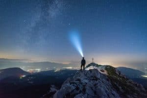 A person with a headlamp looks up at the night sky. A headlamp is a great choice for lighting while camping or RVing.