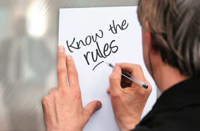 A man writes Know the campground rules on a piece of paper