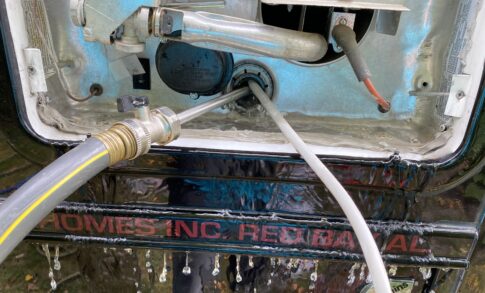A RV water heater tank rinser going into the water heater tank
