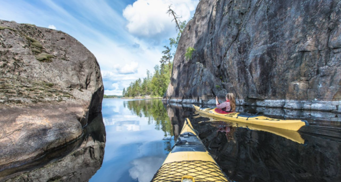 Two people are kayaking. Take the Masterclass of Happiness for free