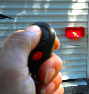 a man points a key fob at his RV trailer lights