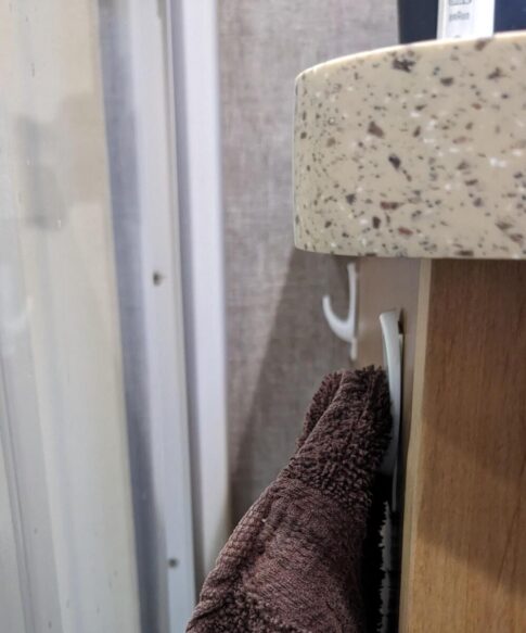 hooks added to the side cabinet panel for towels