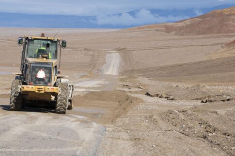 A NPS employee uses a loader to clear flood debris off Badwater Road in Death Valley National Park