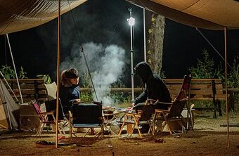 people at a smoky campfire