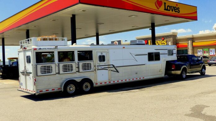 A horse trailer RV at a gas station