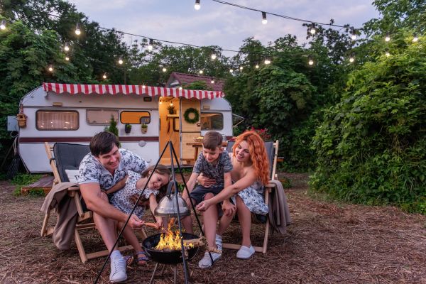 Family RV trip in front of the campfire.