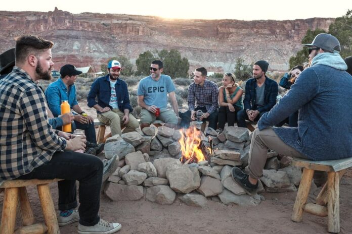A group of friends sits around a campfire