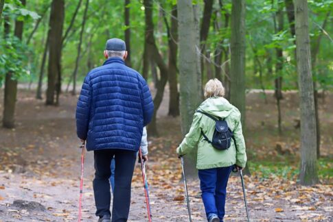 Senior couple with hiking poles on a forested trail Pixabay image