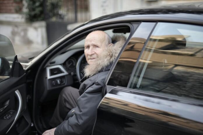 Older man in drivers seat of car